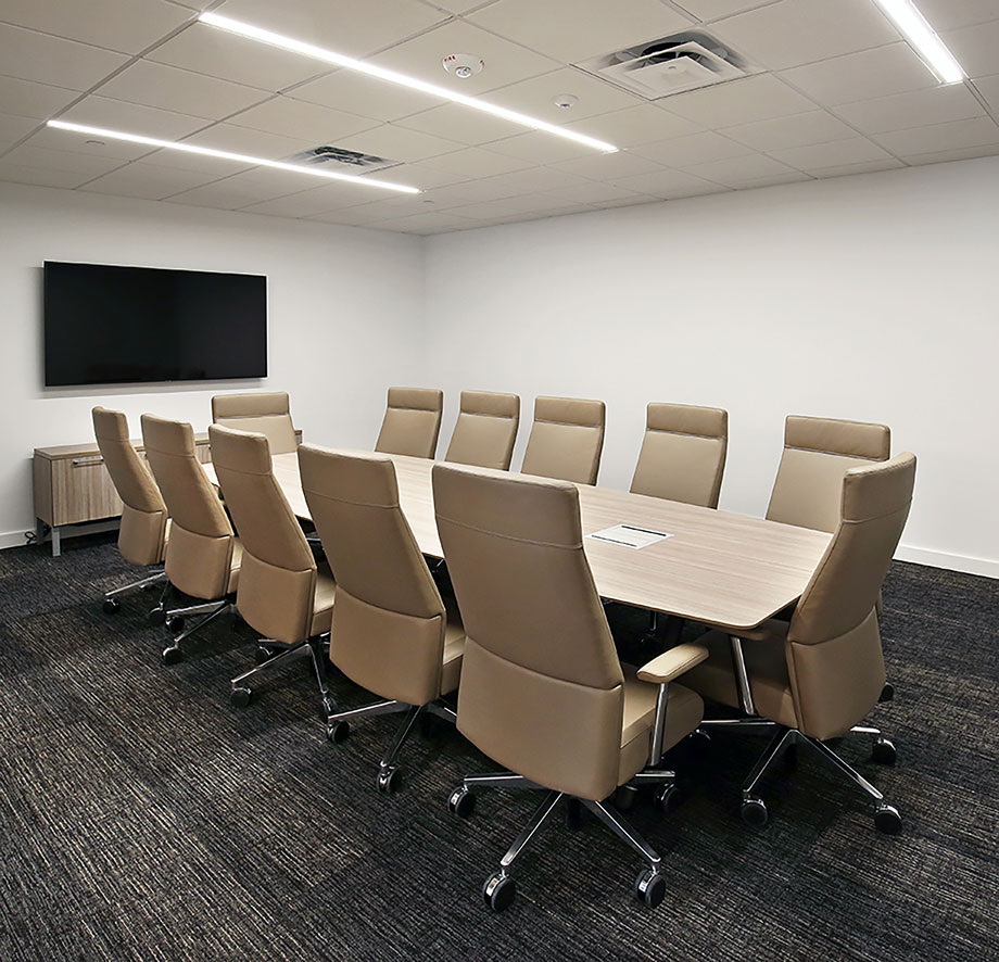 Conference room with 12-person round table and wall-mounted TV